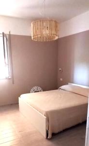 a bedroom with a large bed and a chandelier at Relax e tranquillità a Cala Pisana in Lampedusa