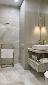 a white bathroom with a sink and a shower at NEW YORK - nowy apartament w centrum miasta - podziemny parking w cenie in Nowy Targ