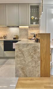 a kitchen with a large marble counter top at NEW YORK - nowy apartament w centrum miasta - podziemny parking w cenie in Nowy Targ