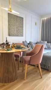 a living room with a table and chairs and a bed at NEW YORK - nowy apartament w centrum miasta - podziemny parking w cenie in Nowy Targ