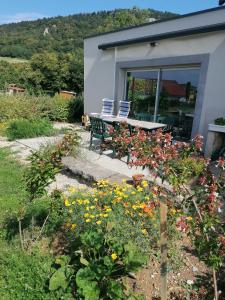 een tuin met een bank en bloemen voor een huis bij Chambre et table d'hôtes La Meule in Poligny