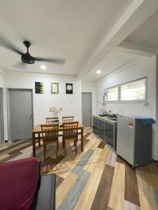 a kitchen and dining room with a table and a refrigerator at RNK BoutiQue HOTEL in Jitra