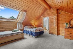 a bedroom with two beds in a log cabin at Finest Retreats - The Logs in Fort William