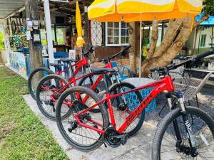 três bicicletas estacionadas uma ao lado da outra numa calçada em Malai Maikhao Near Beach em Ban Mai Salae