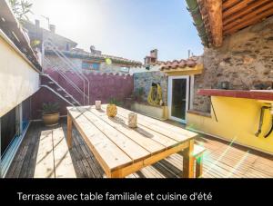 a wooden picnic table on a patio in a house at La maison du Bonheur in Marquixanes +5 photos