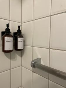 two bottles of soap on a tiled bathroom wall at Gulfhof im historischen Kern in Krummhörn