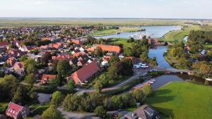 an aerial view of a small town next to a river at Gulfhof im historischen Kern in Krummhörn