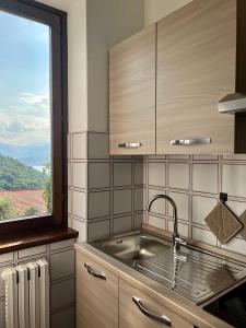 een keuken met een wastafel en een raam bij Casa NiMa Lake Apartment in Perledo