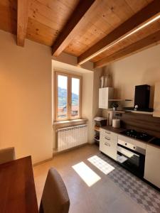 a room with a kitchen with a table and a window at Appartamento del BUFO - appartamento al lago in Endine Gaiano