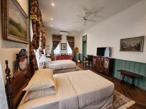 a hotel room with two beds and a tv at La Campagne Villa Chiangmai in Chiang Mai
