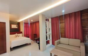 a bedroom with a bed and a couch and red curtains at Sea Horizon Resort in Zamboanguita