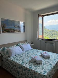 een slaapkamer met een bed met twee handdoeken erop bij Casa NiMa Lake Apartment in Perledo