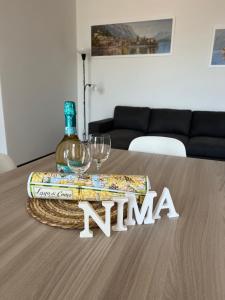 a table with a bottle of wine and two wine glasses at Casa NiMa Lake Apartment in Perledo