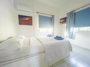 een witte slaapkamer met een bed met handdoeken erop bij Annies Family Villa in Ayia Napa