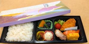 Una caja de almuerzo con arroz y comida. en Hotel Higashimokoto en Abashiri