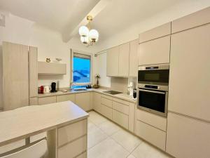 a large kitchen with white cabinets and a window at The Gallery - HyperCentre Reims in Reims