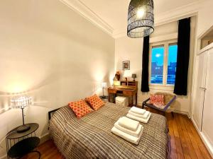 a bedroom with a bed with orange pillows and a window at The Gallery - HyperCentre Reims in Reims