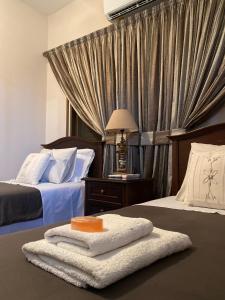 Habitación de hotel con 2 camas y toallas. en Oikos Selinolithos en Alaminos