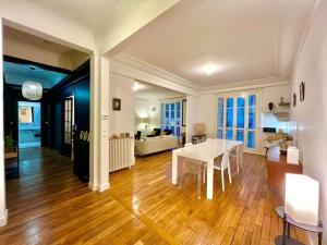 a dining room and living room with a white table at The Gallery - HyperCentre Reims in Reims
