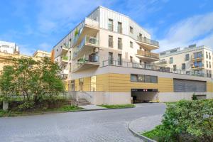 um edifício de apartamentos com uma fachada amarela e branca em Warta River Comfort Apartment em Poznań