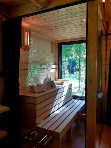 baño de madera con lavabo y ventana en Tree Houses Olszanka, en Puszcza Mariańska