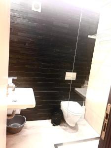 a bathroom with a toilet and a black wall at Botabara Del Mar Boutique in Pomorie