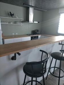 a kitchen with two black chairs and a counter at Appartement tout confort in Guipry-Messac