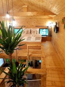 ein Schlafzimmer in einem Blockhaus mit einem Bett und einem Tisch in der Unterkunft Tree Houses Olszanka in Puszcza Mariańska