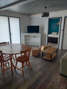 a living room with a table and a bed at Appartement tout confort in Guipry-Messac