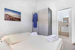 1 dormitorio blanco con 2 camas y una pintura en la pared en Wellness- Doppelhaushälfte "Meer", en Fehmarn