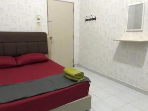 um quarto com uma cama com uma toalha verde em SAHMURA HOMESTAY 1 at GONG BADAK em Kuala Terengganu