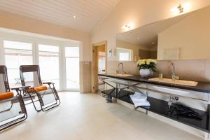 a large kitchen with two sinks and a large mirror at Wellnesshaus "Wind" in Fehmarn