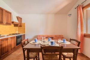 cocina con mesa de madera y sillas en ISA-Residence with swimming-pool in Tanaunella, apartments with air conditioning and private outdoor space, en Tanaunella