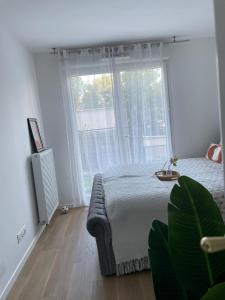1 dormitorio con cama y ventana grande en Magnifique appartement 3 pièces à Vitry-sur-seine (15min de Paris) en Vitry-sur-Seine
