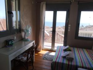 a bedroom with a bed and a desk and a window at Kranai View in Gythio