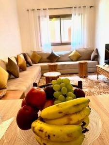 un plato de fruta en una mesa en la sala de estar en ASAMA appartement avec piscine en Marrakech