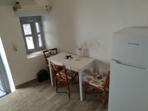 a small kitchen with a white table and two chairs at Kranai View in Gythio