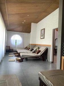 uma fila de camas num quarto grande em GOLDEN LOTUS SPA & HOMESTAY em Ấp Thiện Phước