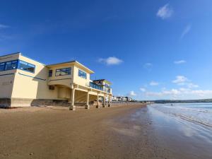 a building on the beach next to the water at 123 On The Sea in Weymouth