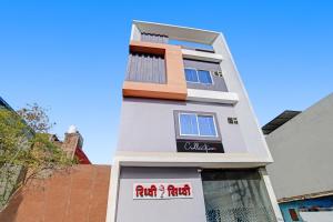 Collection O Hotel Riddhi Siddhi في إندوري: مبنى ابيض امامه لافته