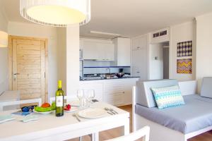 a kitchen and living room with a table and a dining room at Cabot Sivella Apartments in Port de Pollensa +14 photos