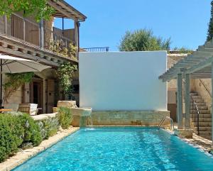 a swimming pool in a backyard with a white screen at Apokryfo Traditional Guesthouse in Lofou