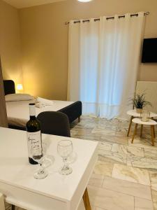 カノニにあるVenetian Gem Central Corfu Retreatのワイングラス付きのテーブルに置かれたボトルワイン