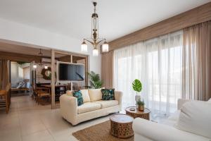 a living room with a white couch and a tv at JW luxury apartment in Chania