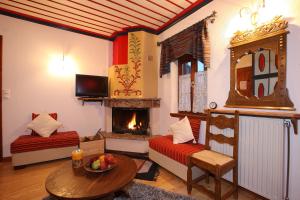 a living room with two beds and a fireplace at Kalliopi in Papingo