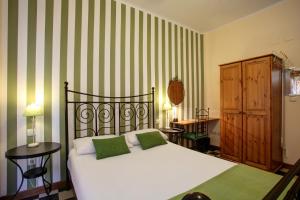 a bedroom with a bed with green and white stripes at Málaga Lodge Guesthouse in Málaga