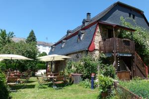 ein Haus mit Tischen und Sonnenschirmen im Hof in der Unterkunft B&B Echternacher Hof in Kinheim