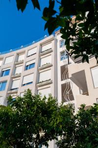 un edificio blanco con árboles delante de él en Bougainville Bay Hotel, en Sarandë