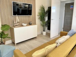 a living room with a couch and a tv at Stunning Beachside 3 Porthcawl in Porthcawl