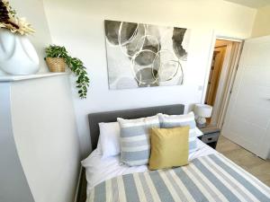 a bedroom with a bed with white and blue pillows at Stunning Beachside 3 Porthcawl in Porthcawl